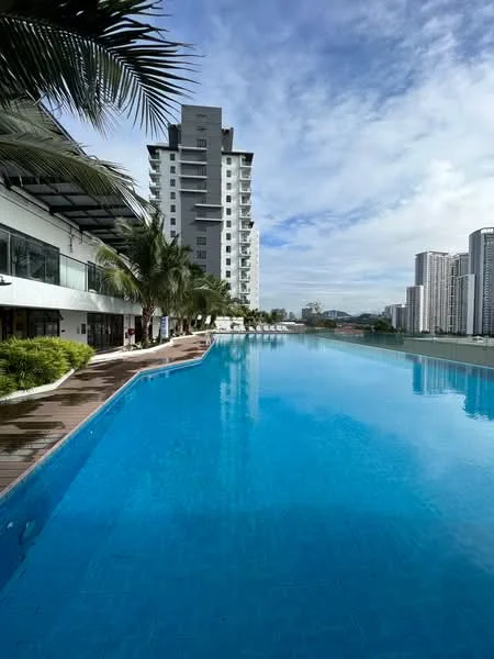 Exterior type: high-rise condominium; features: infinity pool, pool deck with loungers, surrounded by palm trees, glass curtain wall facade, manicured landscaping, city skyline in background; style: modern.