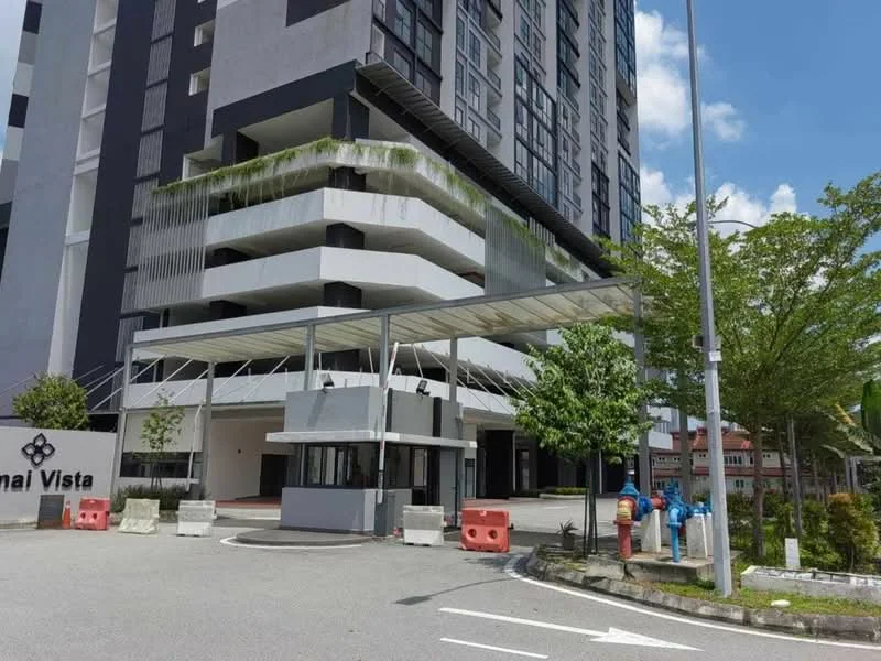 Exterior type: high-rise condominium; features: glass curtain wall, white painted facade, covered entrance with awning, manicured landscaping, paved driveway, security guard house at entrance, perimeter fence, parking area, trees and greenery surrounding the building; style: modern.