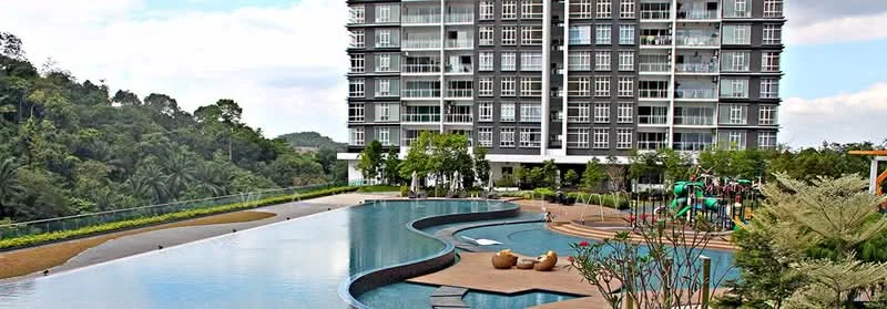 Exterior type: high-rise condominium; features: infinity pool, pool deck with loungers, children's playground, manicured landscaping, surrounded by greenery, glass curtain wall facade, balconies on upper floors, outdoor seating area; style: modern.