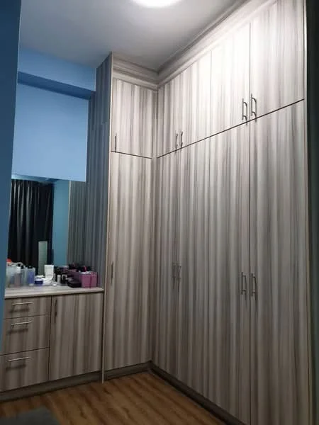 Room features: built-in wardrobe with sliding doors, light wood finish cabinetry, multiple storage compartments, countertop with drawers, laminate flooring, blue painted walls, mirror on the wall, black curtains; style: modern.
