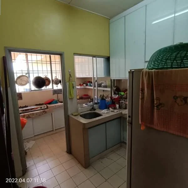 Kitchen features: yellow painted walls, white cabinetry, double-bowl stainless-steel sink, chrome pull-down faucet, ceramic tile flooring, built-in refrigerator, countertop with storage underneath, window with metal grille, kitchen utensils on countertop, wall-mounted shelves, various pots and pans, open shelving with dishes.