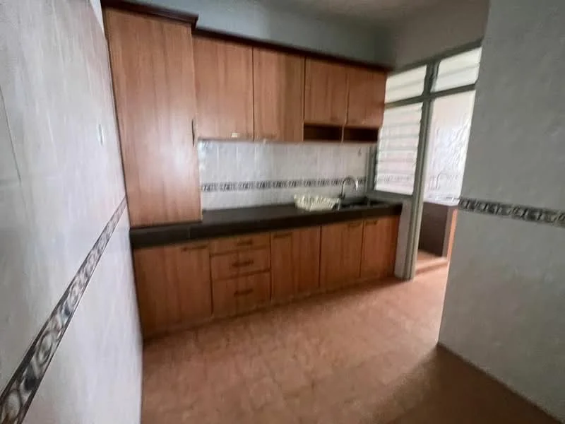 Kitchen features: wooden cabinetry, black countertop, single-bowl stainless-steel sink, chrome faucet, tile backsplash, ceramic tile flooring, window with natural light, built-in storage cabinets, neutral wall color, decorative border tile.
