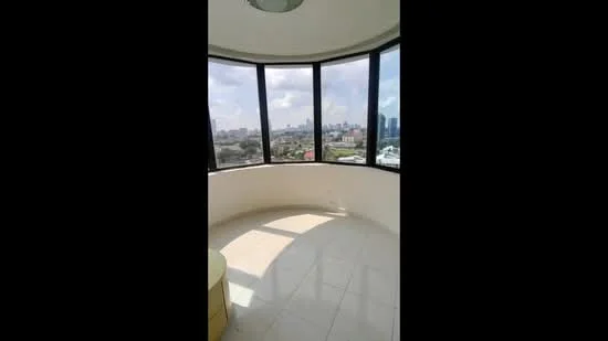 Room features: curved wall of floor-to-ceiling windows, tile flooring, round ceiling light fixture, city skyline view, natural light from windows; style: modern; view: city.