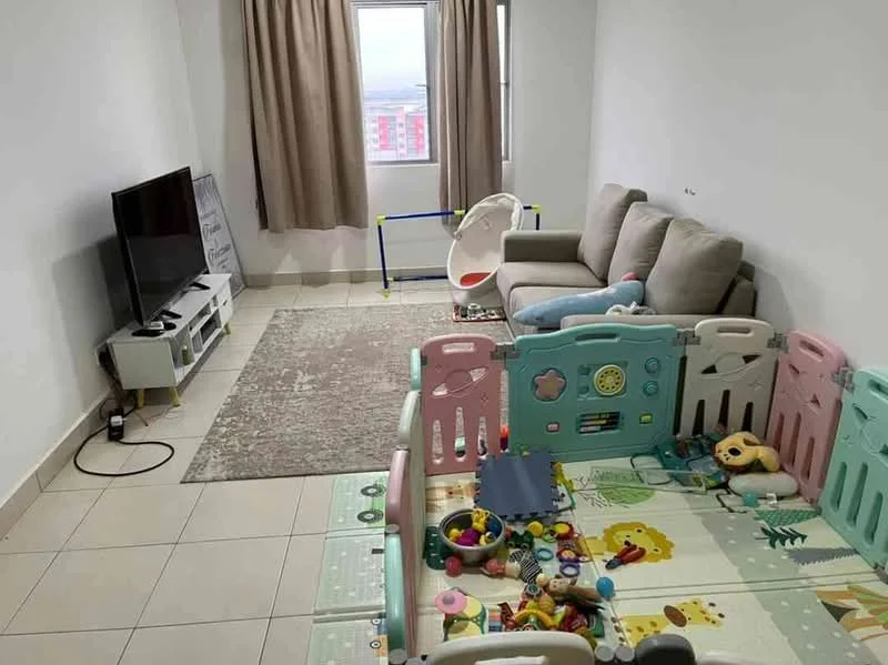 Living features: light grey fabric sofa, TV console with storage, wall-mounted TV, area rug with geometric pattern, floor-to-ceiling window, sheer curtains, light-colored tiled flooring, playpen with colorful panels, toys and play items on the floor; style: modern; view: city.