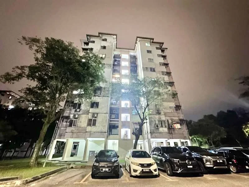 Exterior type: low-rise apartment block; features: concrete facade, grey painted facade, 6-storey building, balconies visible, multiple windows, landscaped area with trees, parking lot with multiple cars, night lighting, surrounded by greenery; style: modern.