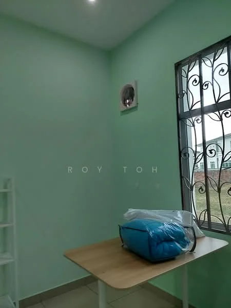 Room features: green painted walls, tile flooring, window with security grille, wall-mounted split AC, wooden table, blue bag.