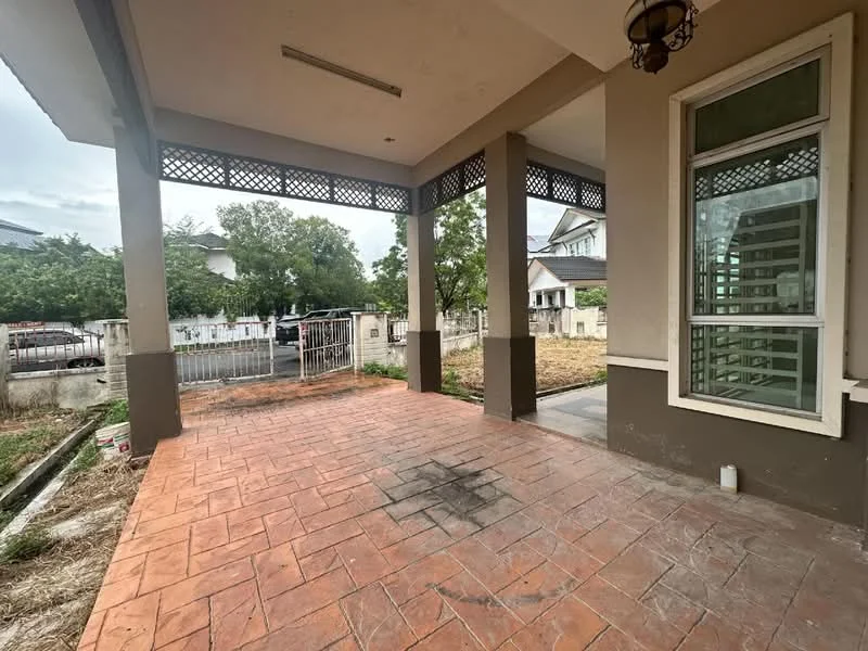 Exterior type: detached bungalow; features: paved patio flooring, covered porch area, decorative wooden lattice, surrounding garden space, fenced perimeter, adjacent driveway, landscaped area with grass, two-storey residential buildings in background; style: modern.
