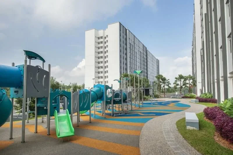 Exterior type: mid-rise condominium; features: children's playground with slides and climbing structures, colorful rubberized flooring, manicured landscaping with shrubs, paved walkway, surrounding palm trees, multi-storey building facade, clear blue sky; style: modern.