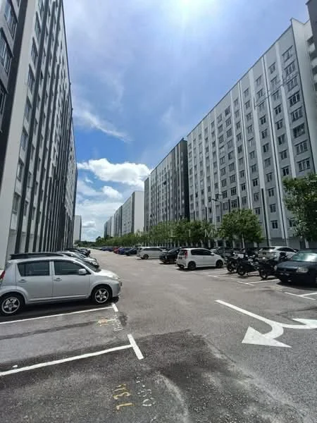 Exterior type: mid-rise condominium; features: multiple mid-rise buildings, concrete facade, white painted facade, landscaped greenery, open-air parking lot, marked parking spaces, surrounded by trees, clear blue sky, sunlight casting shadows, driveway with directional arrows; style: modern.
