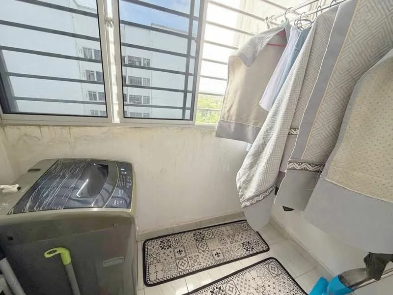 Laundry features: front-load washing machine, white tiled flooring, grey patterned area rug, hanging clothes rack, large window with horizontal bars, white painted walls, natural light from window.