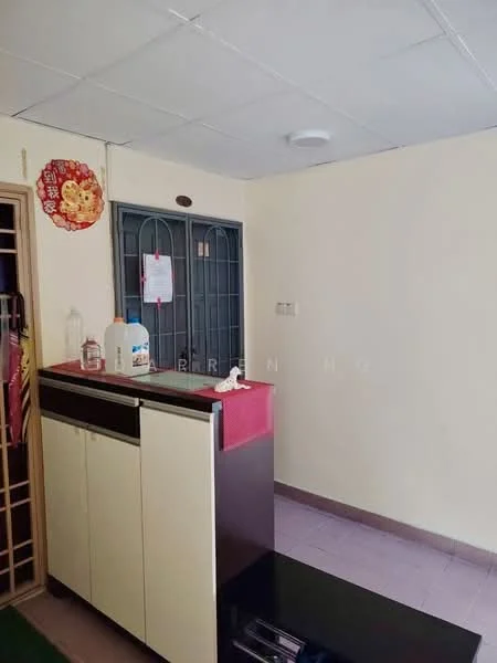 Room features: white painted walls, ceiling with tiles, pink countertop, black cabinet, metal door with grille, floor tiles in light color, shelf unit, bottle on countertop.