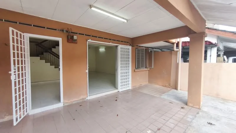 Room features: terracotta tiled flooring, orange painted walls, white ceiling, double French doors, window with security bars, exposed concrete columns, fluorescent lighting, staircase visible in background; style: modern.