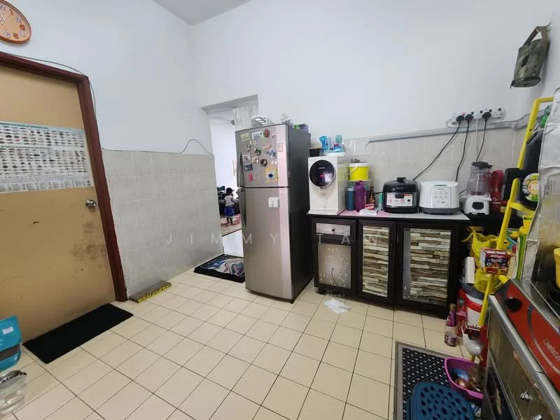Kitchen features: stainless-steel fridge, water dispenser, wood cabinetry with decorative paneling, countertop with appliances, microwave, rice cooker, blender, kettle, dish rack, tile backsplash, cream tiled flooring, wall-mounted electrical outlets, open shelving, floor mat.