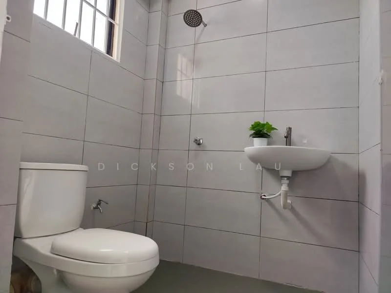 Bathroom features: white one-piece toilet, wall-mounted sink, chrome faucet, shower head, grey tile cladding on walls, grey tile flooring, small potted plant on sink, window for natural light; style: modern.