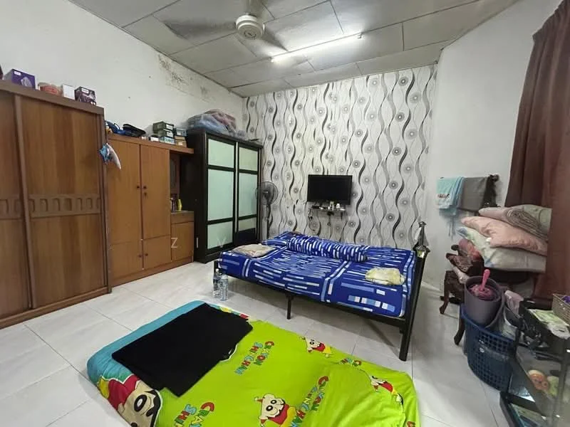 Bedroom features: two single beds with blue bedding, green bedding with cartoon design, wooden wardrobe with sliding doors, black TV mounted on wall, wall-mounted fan, white painted walls, grey patterned wallpaper, white tiled flooring, brown curtains, plastic storage basket, decorative pillows.