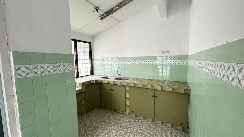 Kitchen features: green tiled walls, white tiled backsplash with decorative pattern, green cabinetry, double-bowl stainless-steel sink, window for natural light, vinyl flooring with geometric pattern, exposed beams on ceiling.