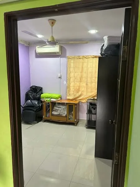 Room features: purple painted walls, cream curtains, 1 wall-mounted split AC, ceiling fan, glossy tile flooring, wooden cabinet, glass-top coffee table, black leather chair, black plastic chair, stack of towels, green blanket.
