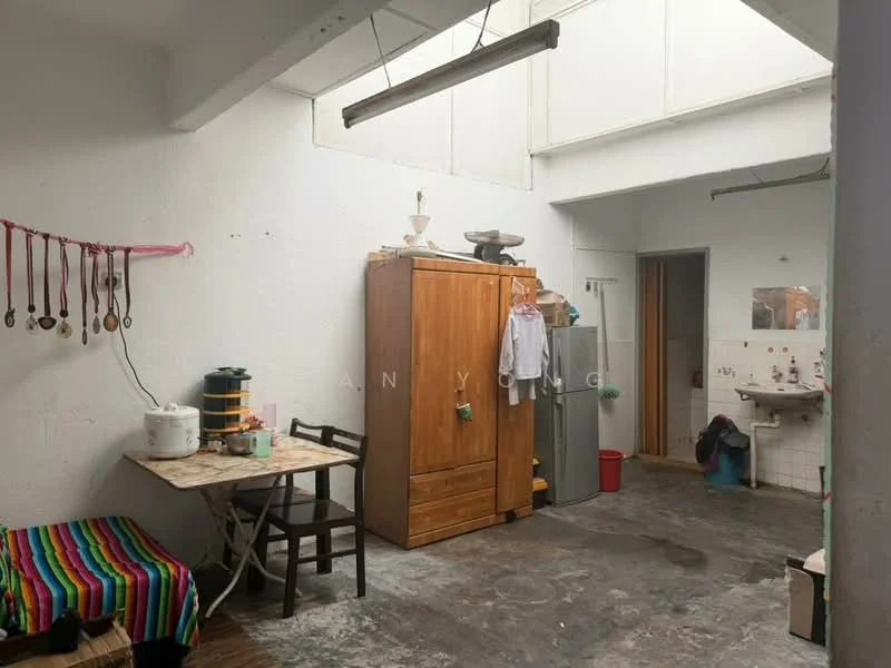 Kitchen features: exposed concrete flooring, white painted walls, wooden cabinetry, kitchen table with chairs, microwave, stainless-steel sink, wall-mounted shelves, hanging storage for utensils, natural light from skylight, decorative colorful striped fabric, refrigerator, trash bin; style: minimalist.