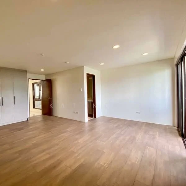 Room features: light wood flooring, white painted walls, recessed downlights, large sliding glass door, floor-to-ceiling windows, built-in wardrobe, open layout, natural light; style: modern.