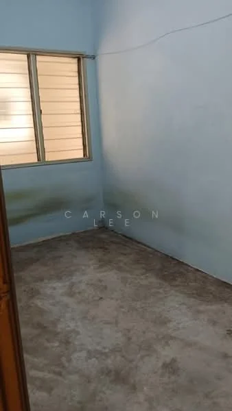 Room features: light blue painted walls, concrete flooring, single window with horizontal slats, no visible furniture or decor.