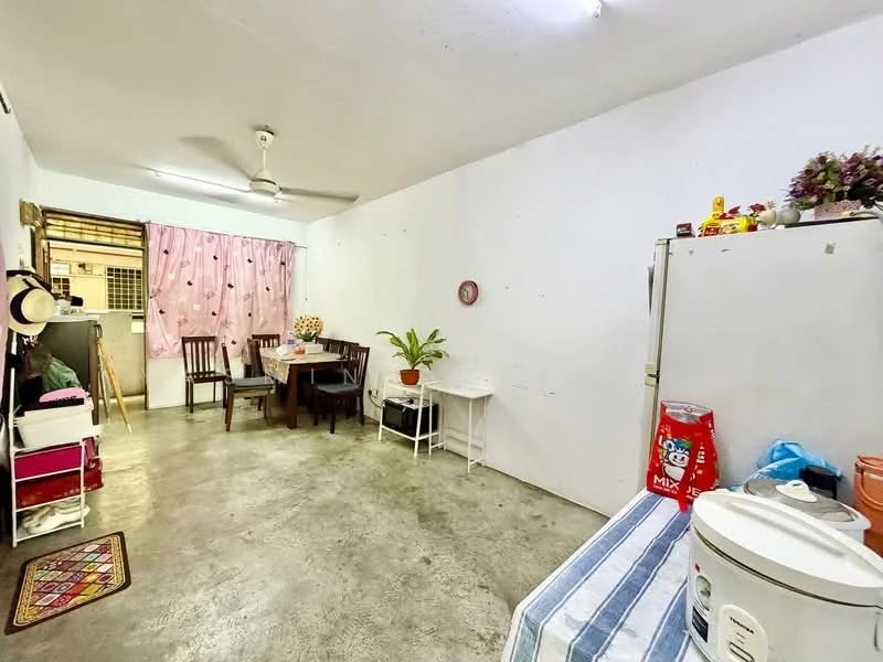 Room features: concrete flooring, white painted walls, ceiling fan, dining table with chairs, refrigerator, rice cooker, plant on table, pink curtains, shelves with storage boxes, decorative items on shelves; style: minimalist.