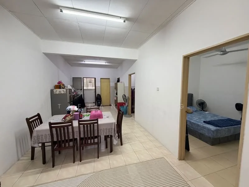 Dining features: dining table with 6 chairs, white tablecloth, ceiling light fixture, tiled flooring, wall-mounted fan, open layout, doorway leading to another room. Bedroom features: queen-size bed, blue bedding, wall-mounted fan, light-colored walls, tiled flooring, window with curtain, doorway leading to hallway. Room features: grey cabinet, open space, additional doorways, light-colored walls, tiled flooring.
