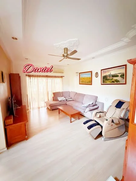 Living features: 3-seater fabric sofa in light grey, wooden coffee table, TV console, wall-mounted TV, ceiling fan with light, laminate flooring, large windows with sheer curtains, decorative wall art, recliner chair, crown moulding on ceiling; style: modern.