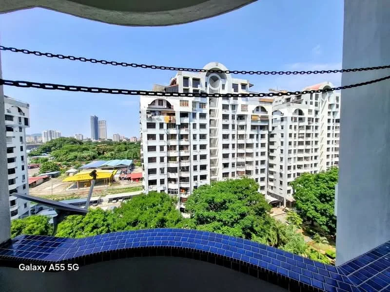 Exterior type: mid-rise condominium; features: white painted facade, recessed balconies, landscaped garden, surrounded by mature greenery, city skyline in background, multiple storeys, large windows, balcony with blue tiled railing; style: modern.