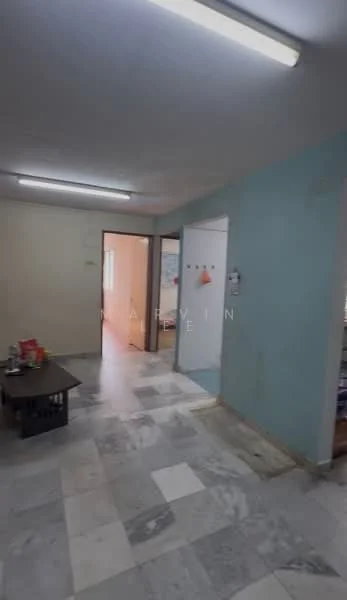 Room features: marble flooring, white walls, light blue accent wall, fluorescent ceiling lights, open layout, doorway leading to another room, doorway leading to a hallway, visible furniture on the left.