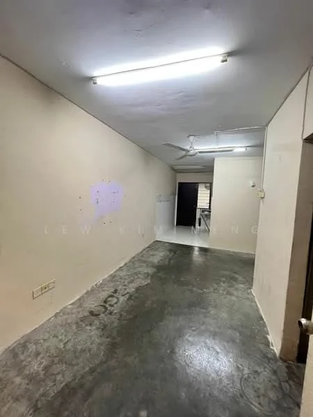 Room features: grey polished concrete flooring, white painted walls, exposed ceiling with fluorescent lights, ceiling fan, doorway leading to another room, unpainted wall sections, no visible furniture or decor; style: minimalist.