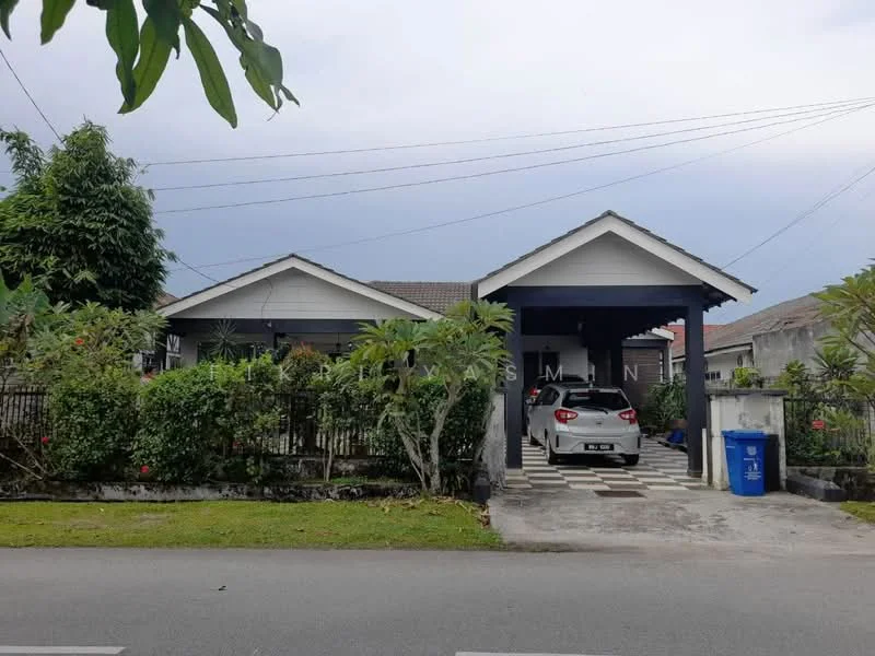 Exterior type: detached bungalow; features: grey painted facade, pitched tile roof, car porch with awning, manicured lawn, mature trees, flowering shrubs, stone-paved walkway, fenced yard, driveway with interlocking pavers; style: modern.