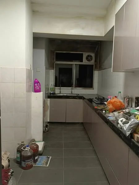 Kitchen features: black granite countertop, light grey cabinetry, double-bowl stainless-steel sink, window above sink, exhaust fan, grey tiled flooring, white tiled walls, various kitchen appliances visible, cluttered countertop with items, storage cabinet, cleaning supplies visible.