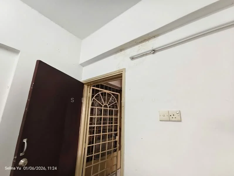 Room features: white painted walls, metal door frame, wooden door, security grille door, light switch, wall-mounted light fixture.