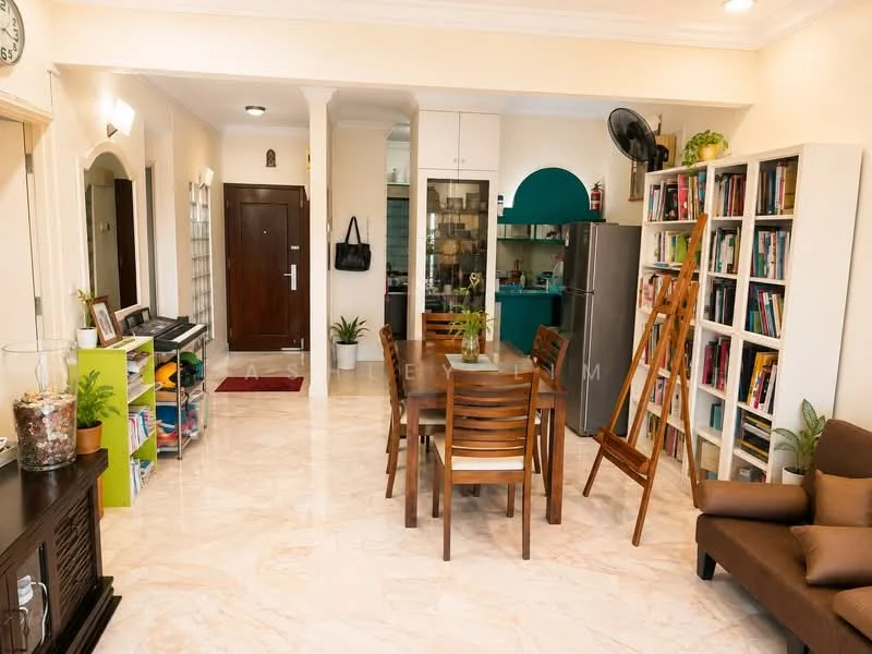 Living features: marble tile flooring, cream painted walls, recessed downlights, 5-blade ceiling fan, wooden dining table with 6 chairs, brown fabric sofa, bookshelves with books, green accent wall in kitchen area, stainless-steel fridge, open layout, potted plants, decorative artwork on wall; style: modern. Kitchen features: green cabinetry, glass-front upper cabinets, stainless-steel fridge, countertop with space for appliances, open layout to living area; style: modern.
