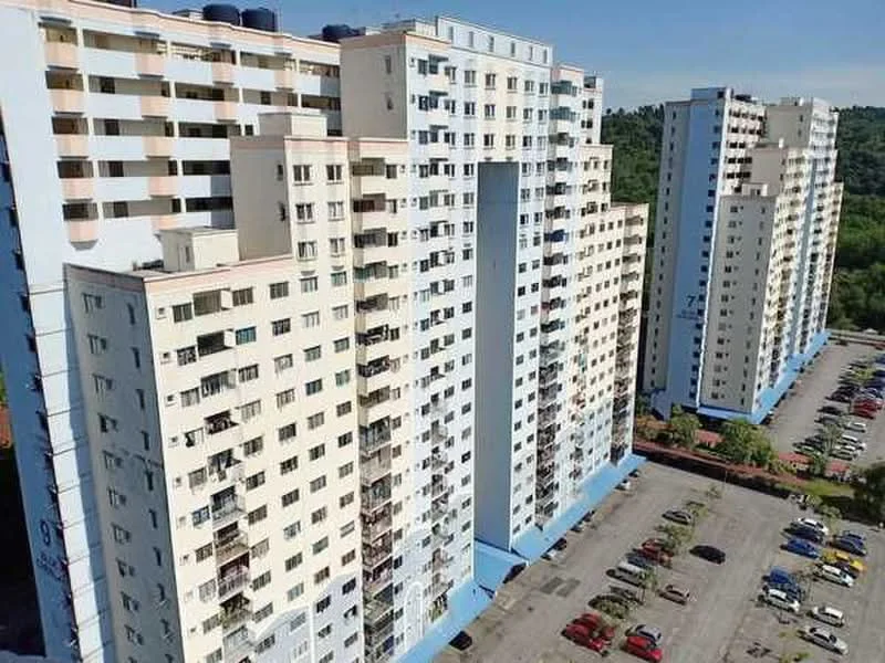 Exterior type: high-rise condominium; features: white painted facade, multiple storeys, balconies on upper floors, parking lot with marked spaces, surrounded by greenery, clear blue sky, landscaped area at the base; style: modern.