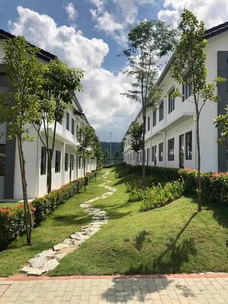 Exterior type: linked terrace house; features: white painted facade, grey accent walls, manicured lawn, stone-paved walkway, landscaped garden with shrubs, trees lining the pathway, two-storey buildings, clear blue sky, clouds, surrounded by greenery; style: modern.