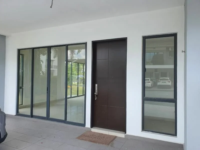 Exterior features: main entrance door with wood finish, large glass sliding doors, floor-to-ceiling windows, grey tiled flooring, white painted facade, minimalist design, visible parking area, surrounded by greenery; style: modern.