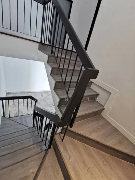 Room features: staircase with wooden steps, metal railing, light-colored walls, laminate flooring, open space at the bottom of the stairs, natural light from upper levels; style: modern.
