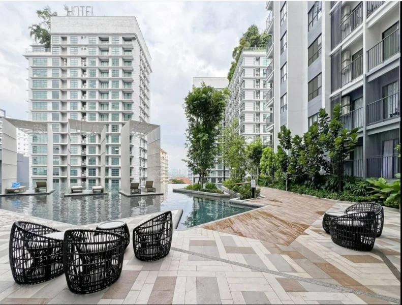 Exterior type: high-rise condominium; features: infinity pool, pool deck with loungers, landscaped garden, manicured lawn, modern outdoor seating, surrounded by greenery, water feature, paved walkway; style: modern.