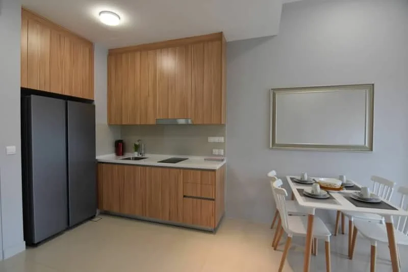 Kitchen features: stainless-steel fridge, wood cabinetry, white countertop, built-in cooktop, extraction hood, grey backsplash, recessed ceiling lights, tile flooring, dining table with white chairs, decorative mirror; style: modern.