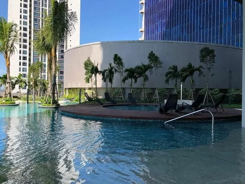 Exterior type: swimming pool deck; features: infinity pool, pool deck with loungers, tropical landscaping, palm trees, surrounding greenery, modern architectural design, water feature, swimming pool with steps; style: modern.