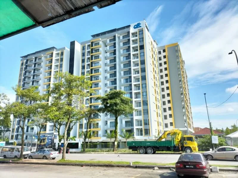 Exterior type: mid-rise condominium; features: yellow and grey painted facade, glass curtain wall, recessed balconies, approximately 8-storey high-rise, manicured landscaping, surrounded by mature trees, parking lot in front, urban context with nearby road; style: modern.