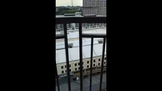 Room features: balcony railing, city view, adjacent buildings, overhead power lines, flat roof of nearby buildings; view: city.