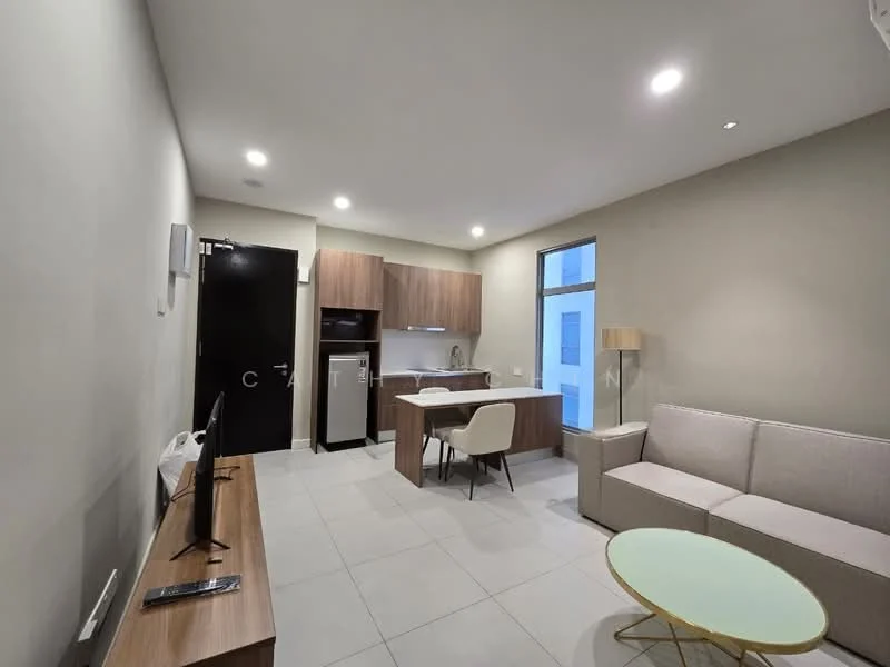 Living features: grey fabric sofa, light wood coffee table, TV console, wall-mounted TV, recessed downlights, tile flooring, cream painted walls, large window with natural light, open-plan layout, kitchenette with wood cabinetry, stainless-steel fridge, built-in oven, countertop with bar seating; style: modern.