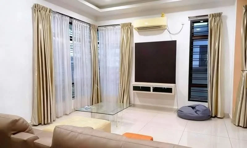 Living features: cream painted walls, white ceiling with recessed lighting, large floor-to-ceiling windows, sheer curtains, beige curtains, glass coffee table, beige leather sofa, bean bag chair, wall-mounted TV console, air conditioning unit; style: modern.