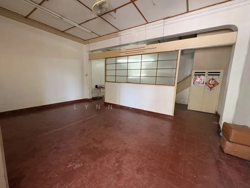 Room features: red tile flooring, white painted walls, wooden ceiling with beams, ceiling fan, partition wall with glass panels, staircase visible in background, built-in storage cabinet, empty space; style: traditional.