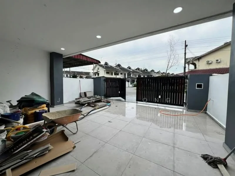 Exterior features: paved flooring, black metal gate, white painted walls, overhead lighting, surrounding residential buildings, concrete driveway, visible construction materials, drainage hose; style: modern.