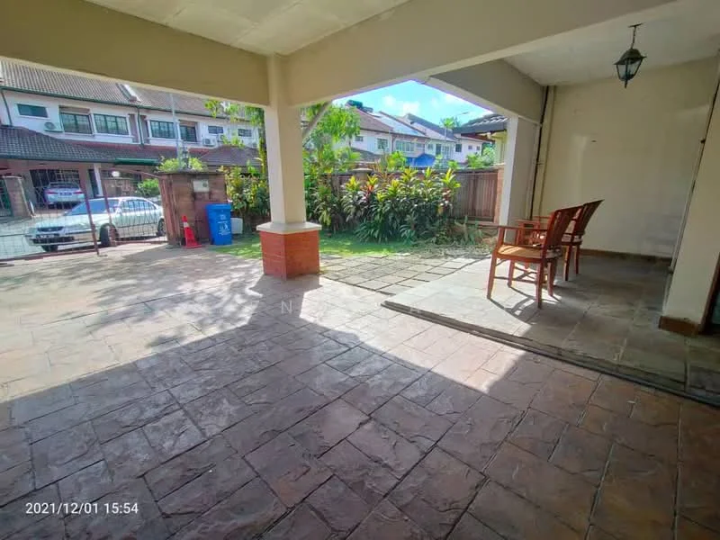 Exterior type: linked terrace house; features: paved stone flooring, covered porch area, wooden chairs, lush greenery, fenced garden, car parking area visible, outdoor lighting fixture, residential neighborhood view; style: modern.