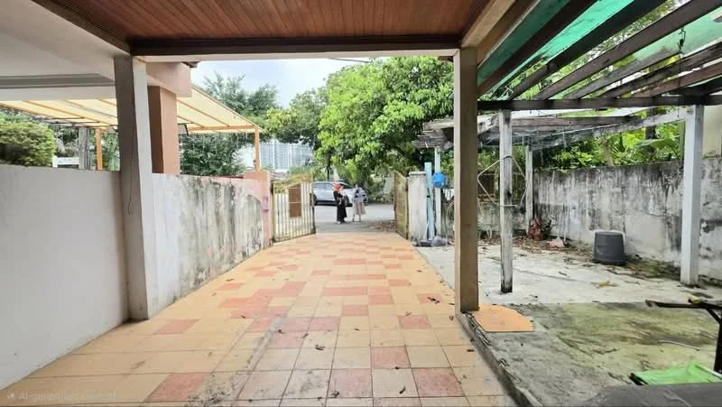 Exterior features: paved driveway, partially covered area with awning, greenery with trees, fenced perimeter, concrete walls, outdoor storage area, visible parking space, adjacent road access.