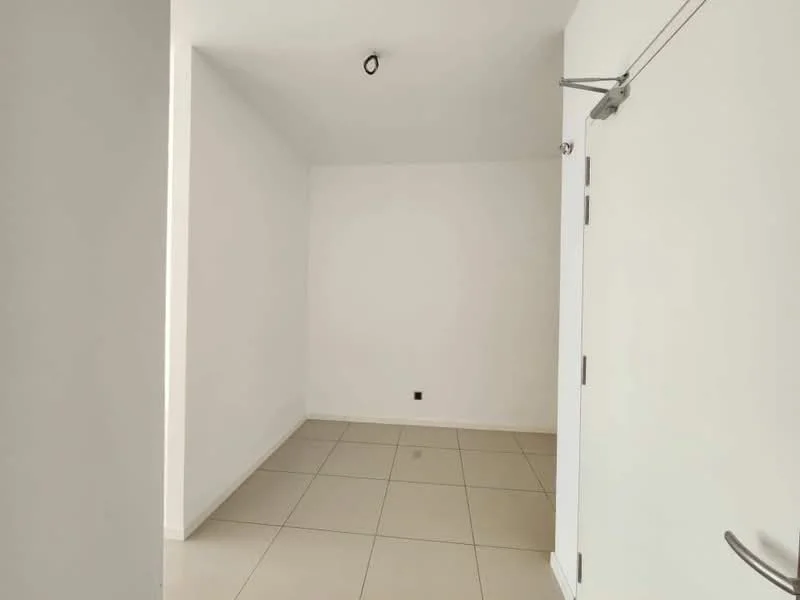 Room features: white painted walls, tile flooring, ceiling light fixture, single door, door handle, corner wall.